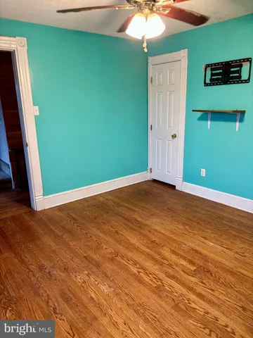 an empty room with wooden floor and entryway