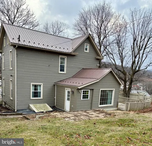 a view of a yard in front of a house with large windows
