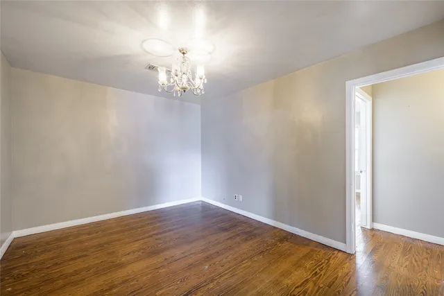 a view of a room with wooden floor and chandelier