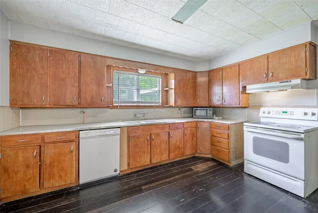 a kitchen with granite countertop white cabinets and white appliances