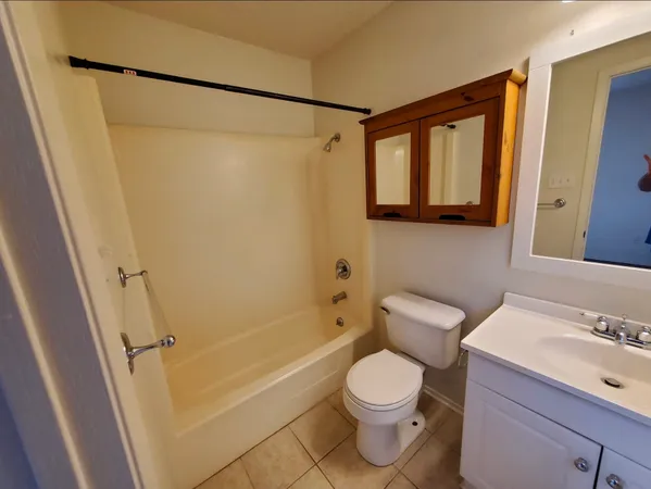 a bathroom with a toilet sink shower and a mirror