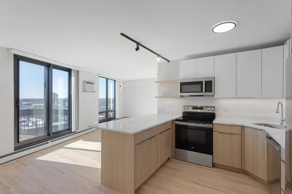 a kitchen with stainless steel appliances granite countertop a stove top oven a sink and a refrigerator