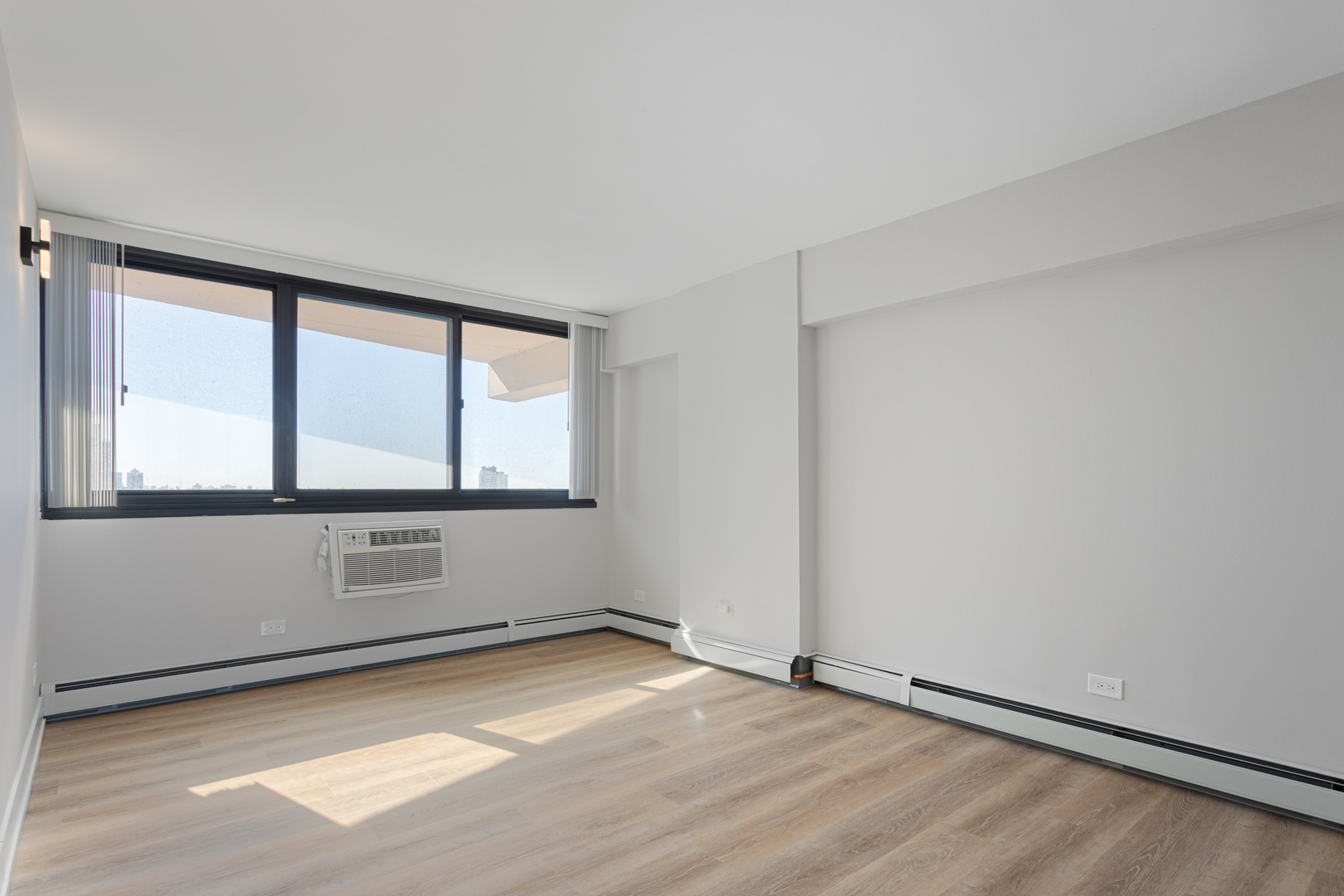 6166 North Sheridan Road, Unit 6K Chicago, IL 60660 - Photo 8 of 21 an empty room with wooden floor and windows