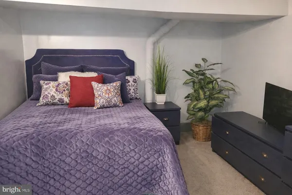 a bedroom with a bed and a potted plant
