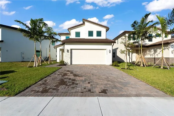 a front view of a house with a yard and a garage