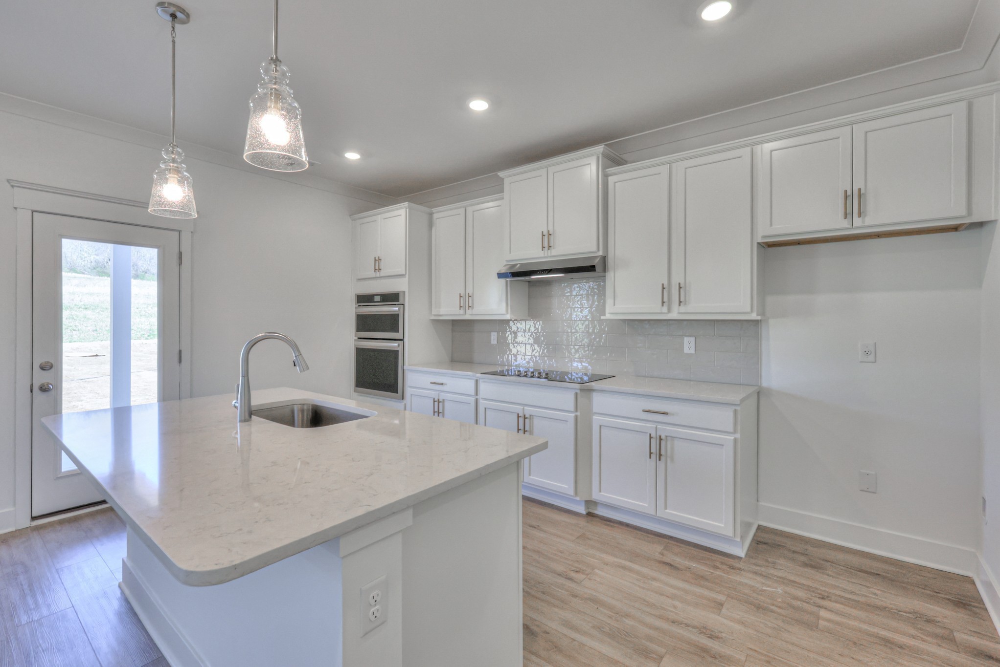 2584 Bluestem Road Columbia, TN 38401 - Photo 16 of 35 a kitchen with kitchen island granite countertop a sink cabinets and wooden floor