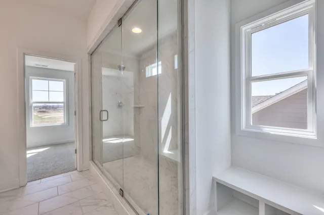 a spacious bathroom with a shower sink and mirror