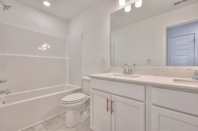 a bathroom with a granite countertop sink a toilet and a bathtub