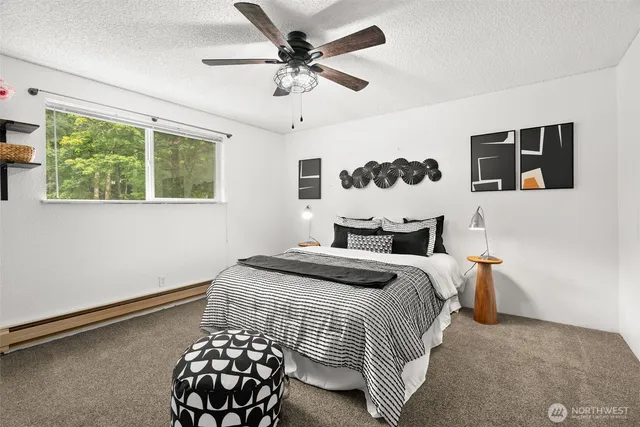 a bedroom with a bed lamp and a large window