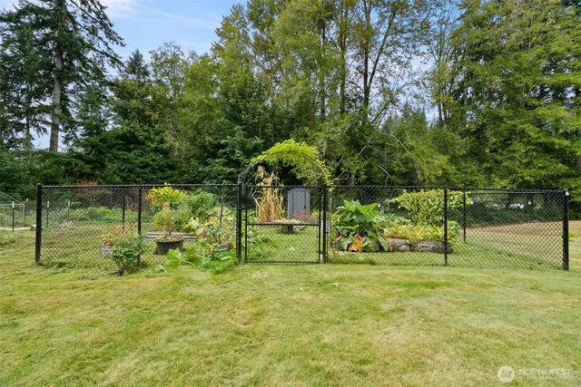 a view of a house with yard and trees in the background