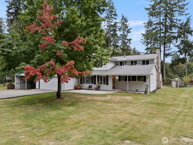 a front view of a house with a garden and trees
