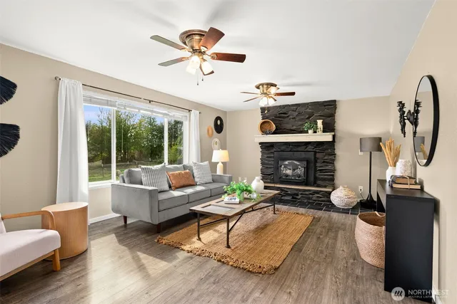 a living room with furniture a fireplace and a large window