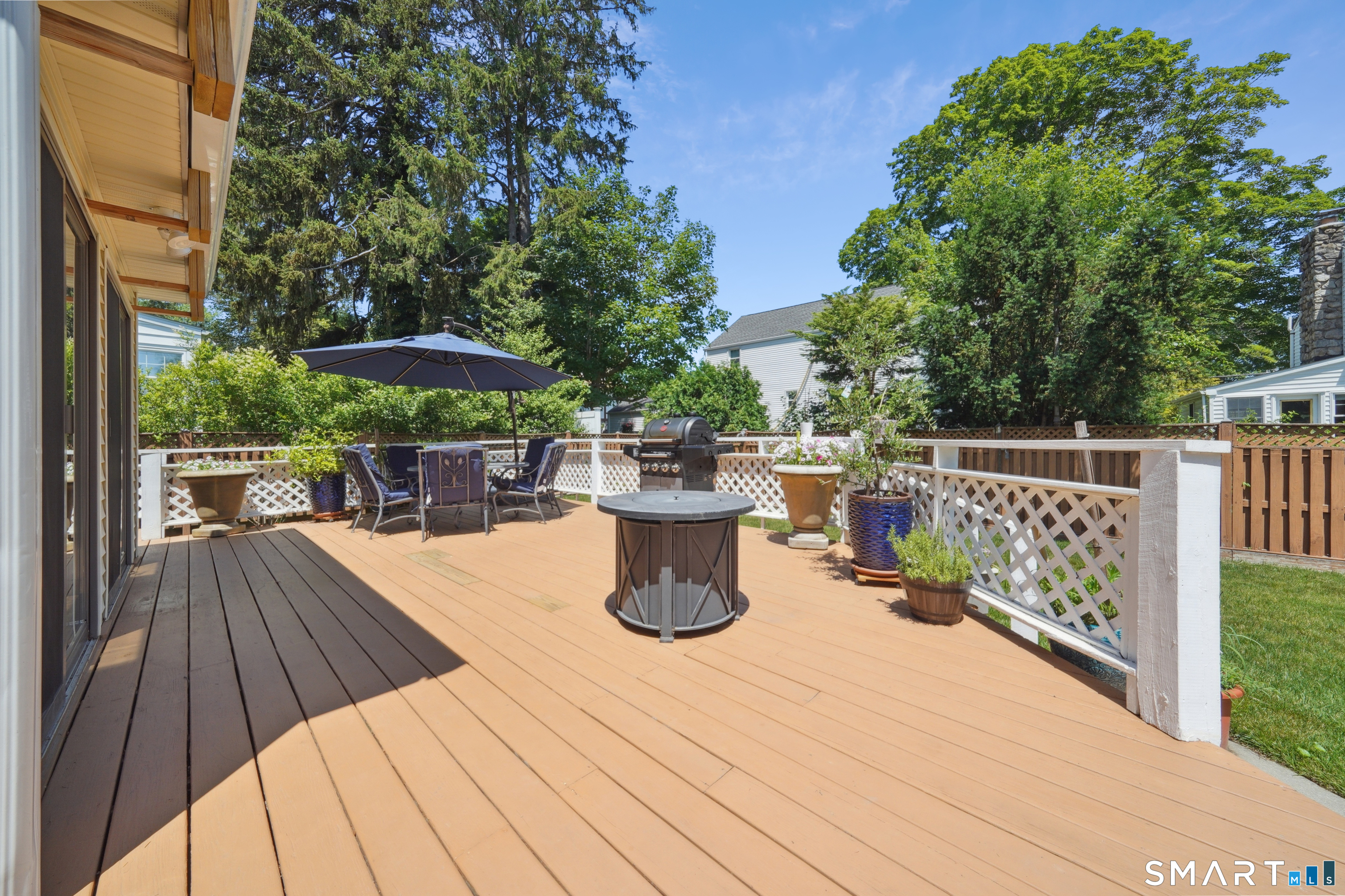 20 Norman Road Stamford, CT 06906 - Photo 23 of 35 a view of a roof deck with table and chairs under an umbrella with wooden floor