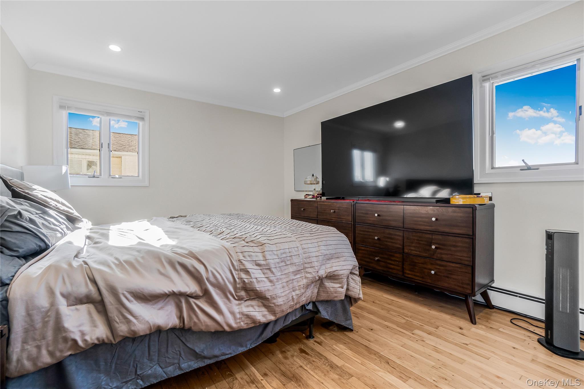 107 Beverly Road Massapequa, NY 11758 - Photo 18 of 30 a bedroom with a bed and a flat screen tv