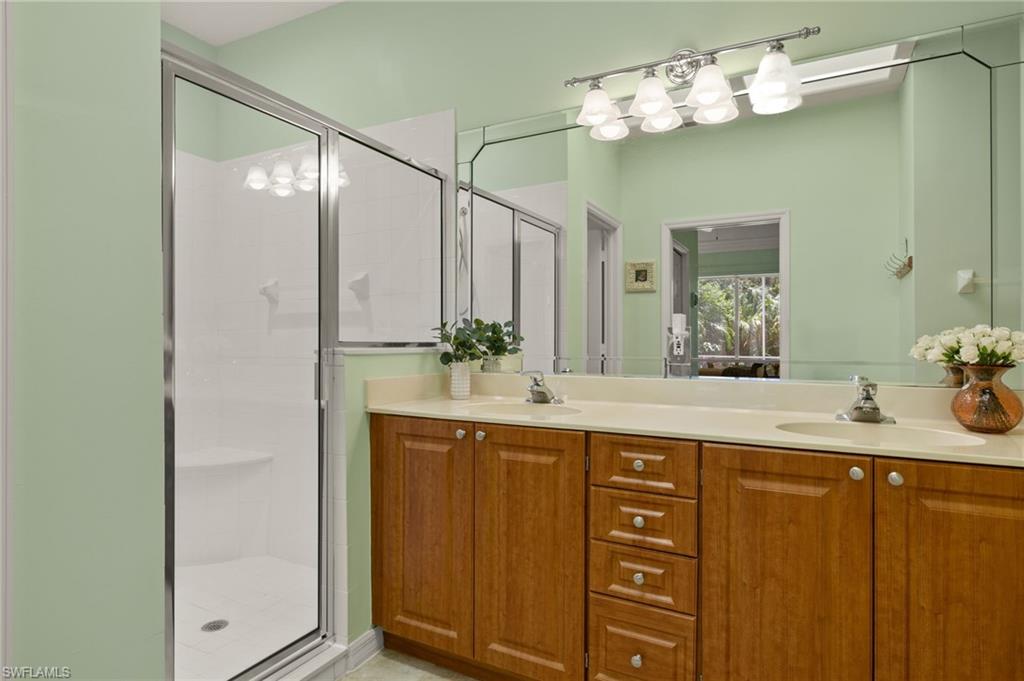 1409 Athol Way, Unit 101 Naples, FL 34104 - Photo 14 of 37 Bathroom with a sink, a stall shower, and double vanity