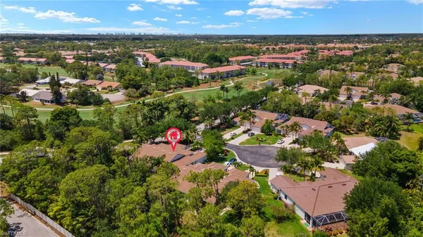 an aerial view of residential houses with outdoor space and trees