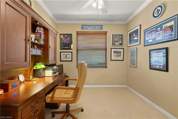 a view of a workspace with furniture and a window