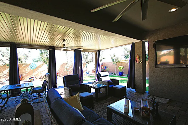 a living room with furniture a flat screen tv and kitchen view