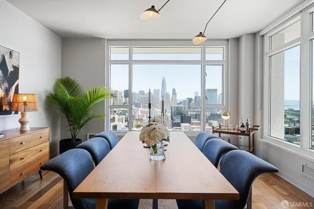 a dining room with furniture a large window and a flat screen tv