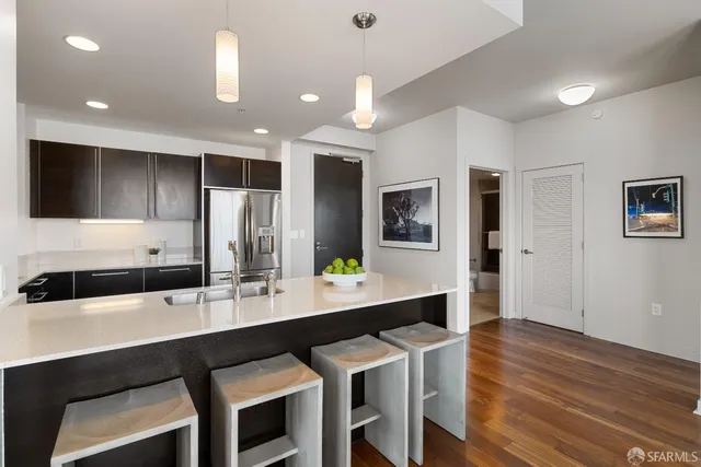 a kitchen with a dining table chairs cabinets and stainless steel appliances