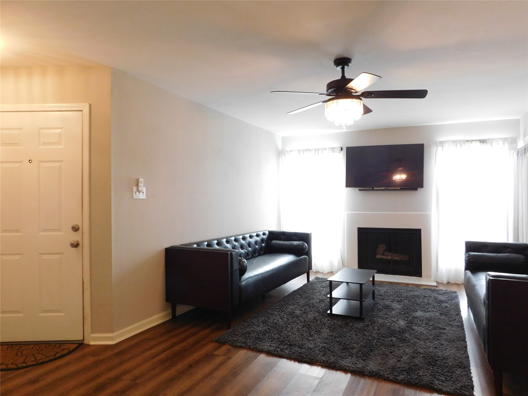 10101 South Gessner Road, Unit 912 Houston, TX 77071 - Photo 6 of 47 a living room with furniture a fireplace and a flat screen tv
