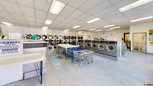 a living room with lots of furniture and clutter
