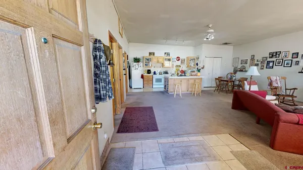 a view of a dining room with furniture and a kitchen