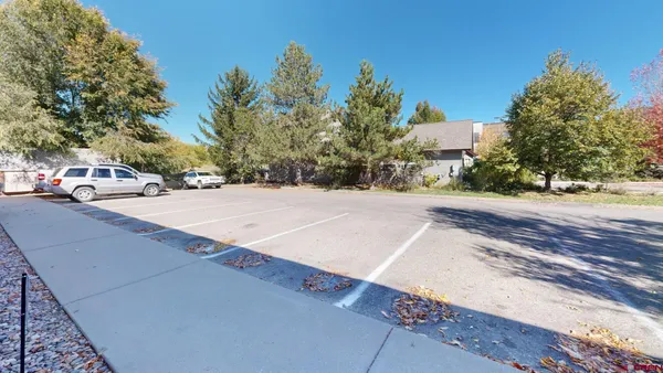 a view of a dining room with furniture a rug and windows