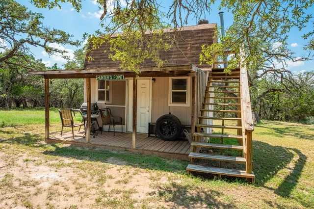 a view of a chair and table in backyard of the house