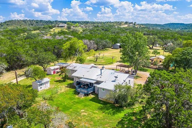 an aerial view of a house with a garden and lake view