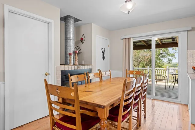 a dining room with furniture large windows and wooden floor