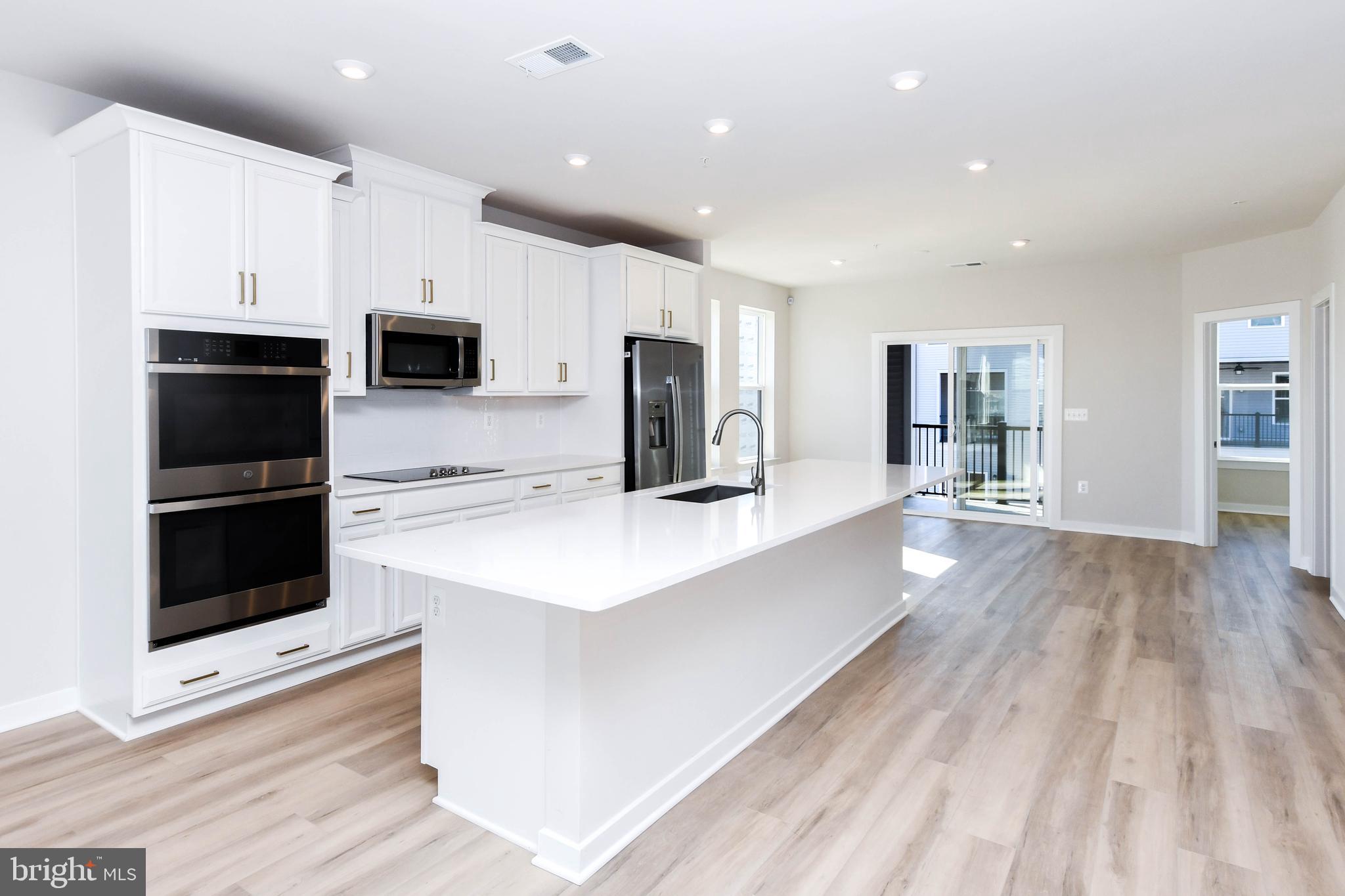a kitchen with stainless steel appliances a kitchen island hardwood floor sink and stove