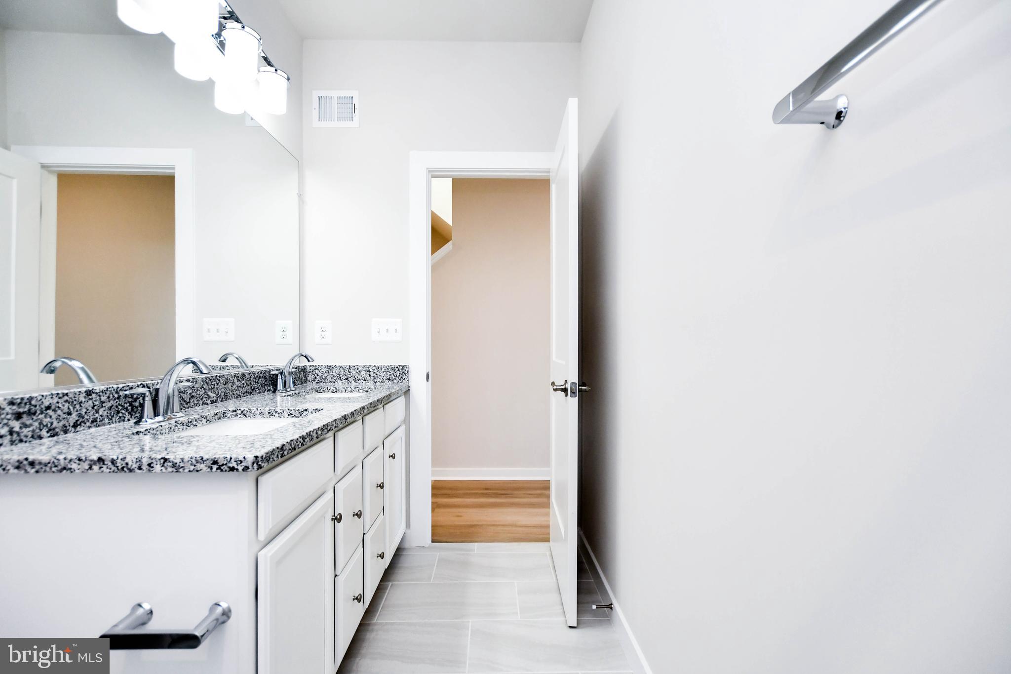 44502 Wolfhound Square Ashburn, VA 20147 - Photo 30 of 100 a bathroom with a granite countertop sink and a mirror