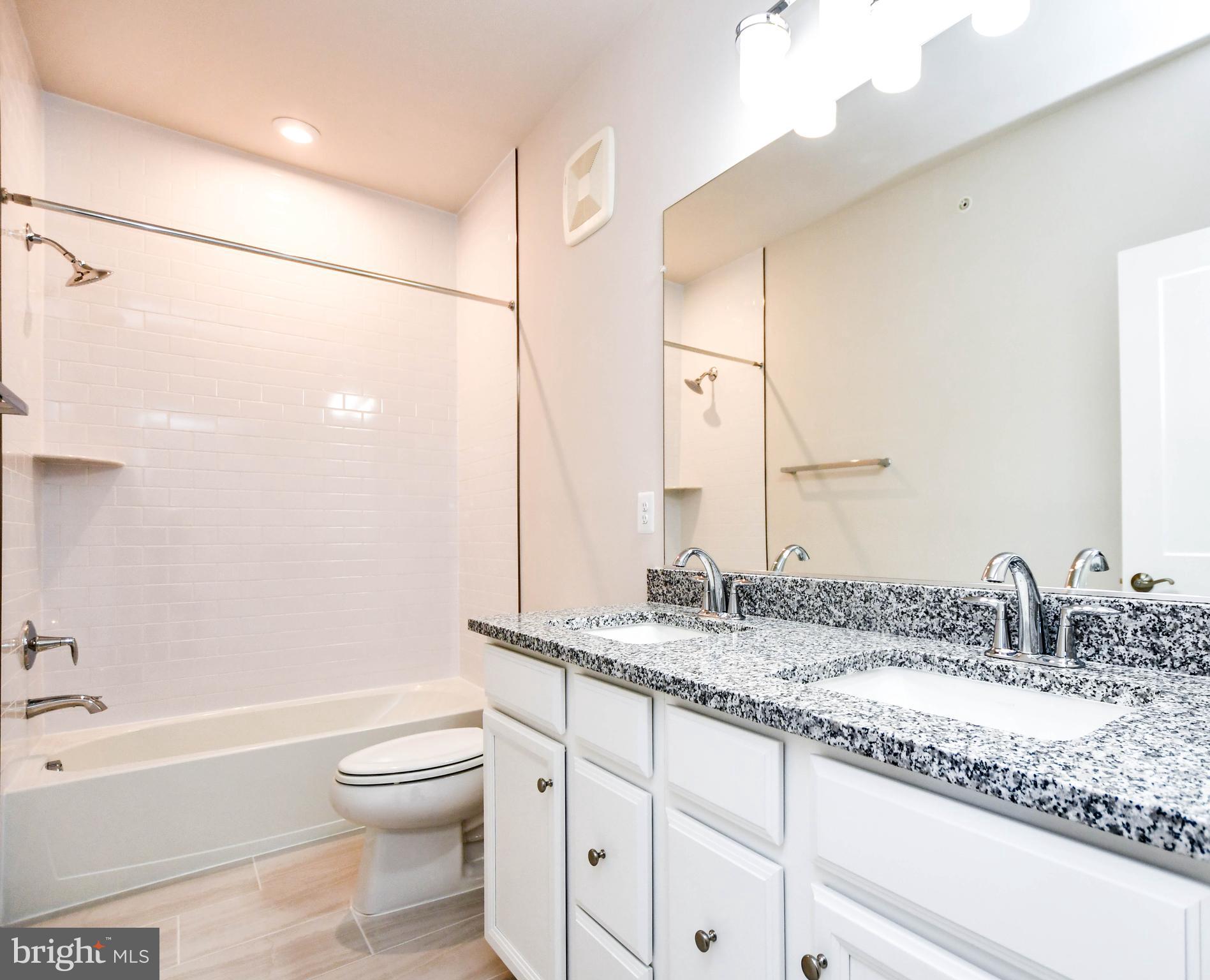 44502 Wolfhound Square Ashburn, VA 20147 - Photo 31 of 100 a bathroom with a granite countertop sink a toilet and shower