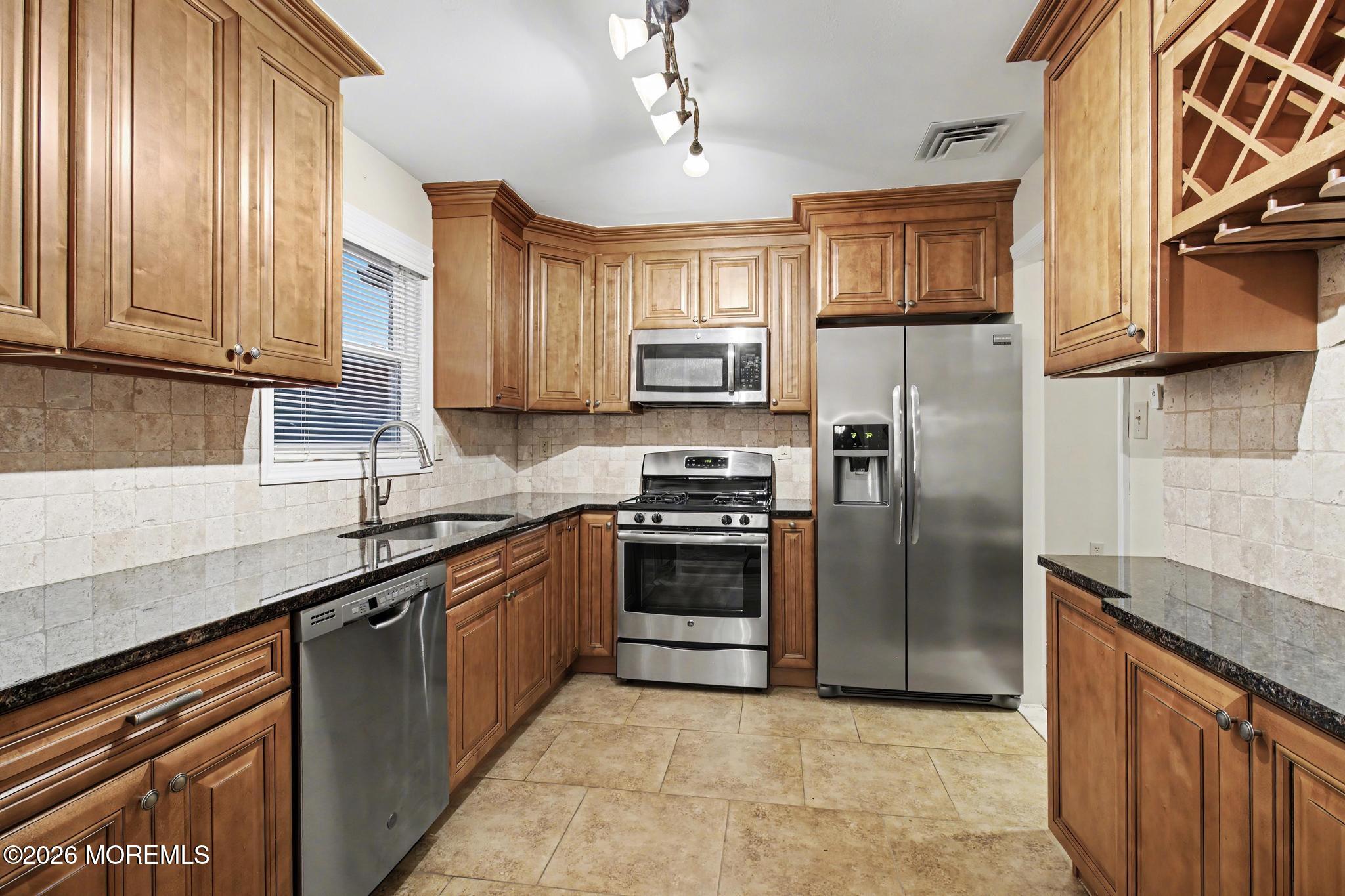 203 Blake Circle Brick, NJ 08724 - Photo 14 of 40 a kitchen with stainless steel appliances granite countertop a refrigerator a sink dishwasher a stove and white cabinets with wooden floor