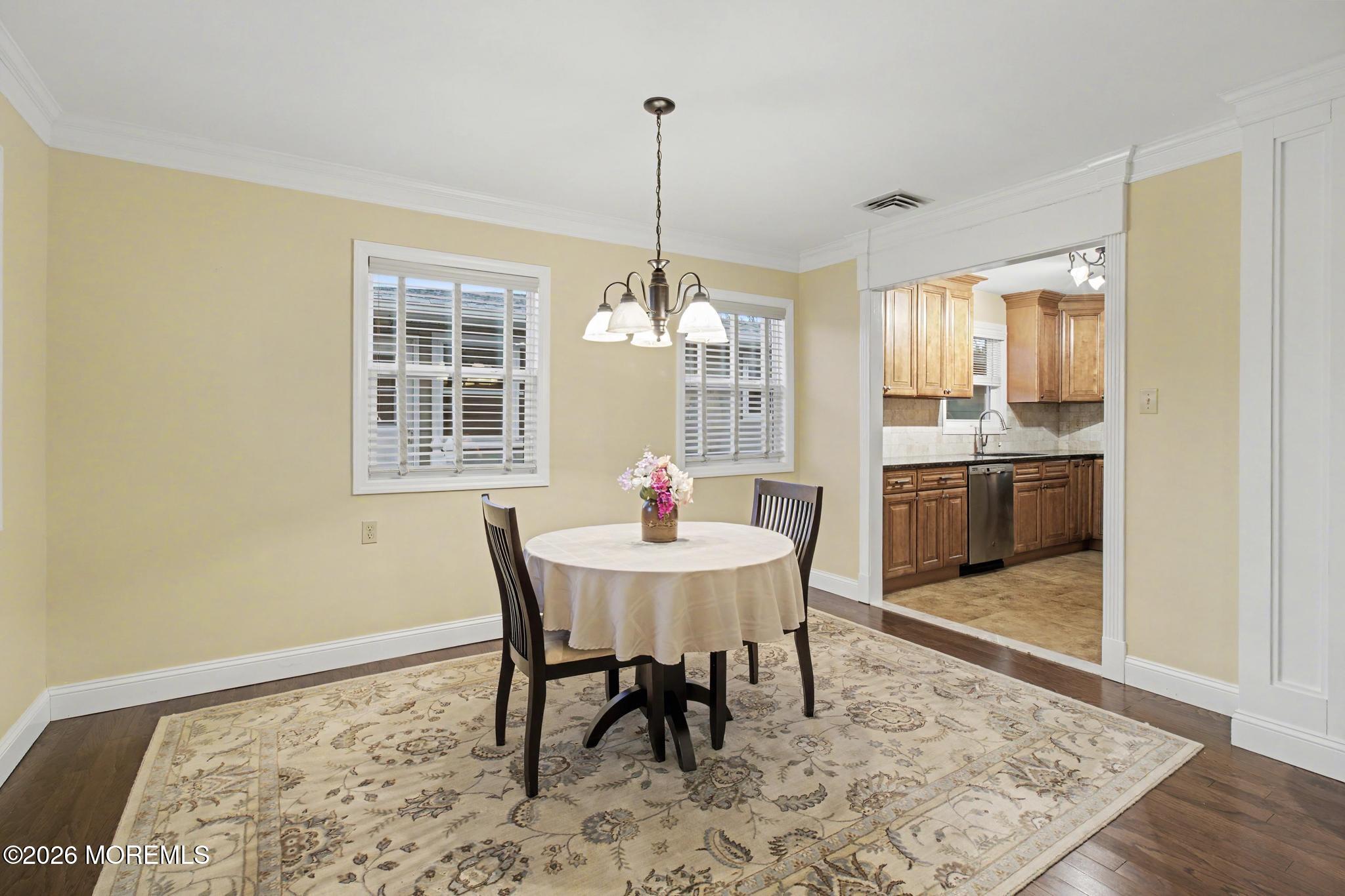 203 Blake Circle Brick, NJ 08724 - Photo 17 of 40 a dining room with furniture a chandelier and wooden floor