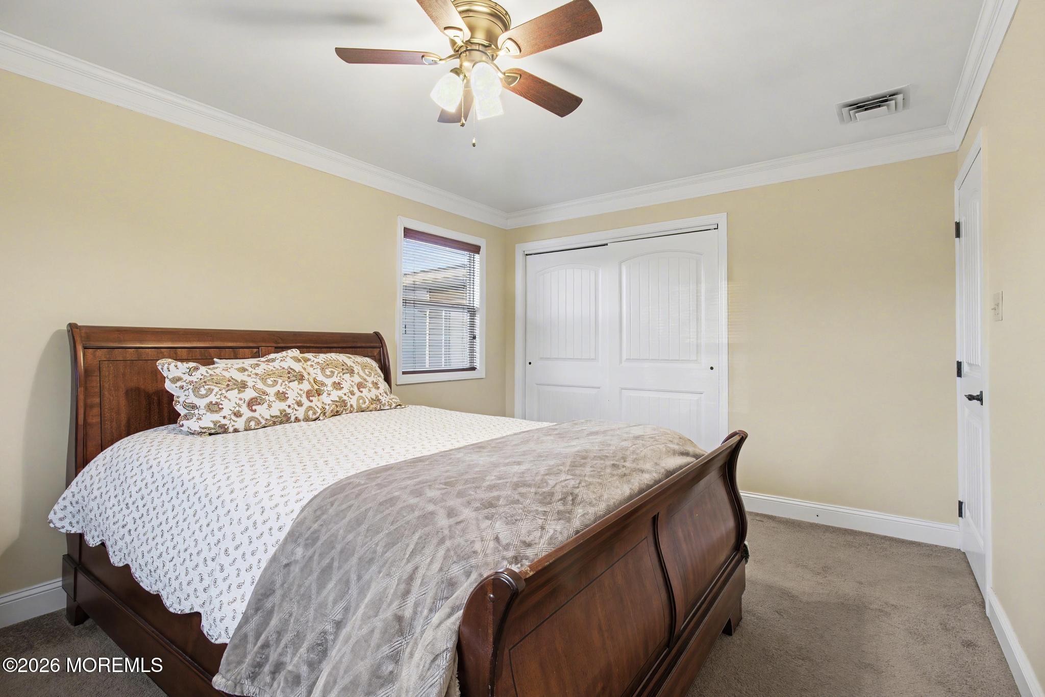 203 Blake Circle Brick, NJ 08724 - Photo 20 of 40 a bedroom with a bed and a chandelier