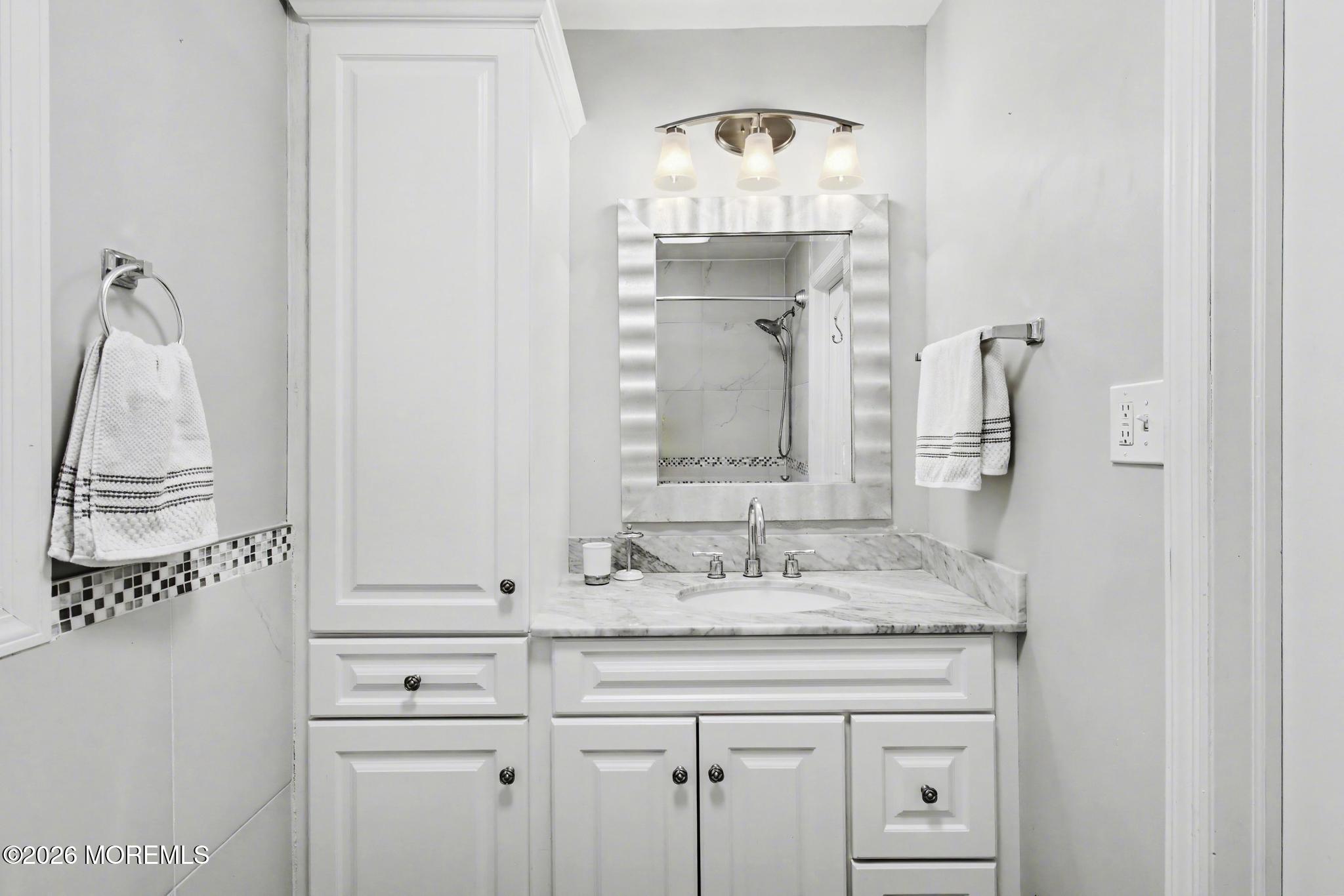 203 Blake Circle Brick, NJ 08724 - Photo 24 of 40 a bathroom with a granite countertop sink and a mirror