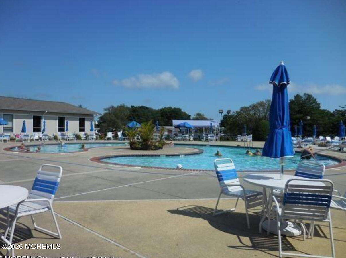 203 Blake Circle Brick, NJ 08724 - Photo 33 of 40 a view of a patio with table and chairs potted plants and a palm tree