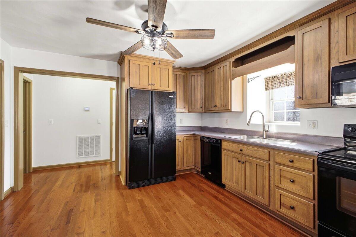 3282 Absalom Smith Road Salem, VA 24153 - Photo 10 of 59 a kitchen with stainless steel appliances granite countertop a refrigerator a sink dishwasher a stove and white countertops with wooden floor