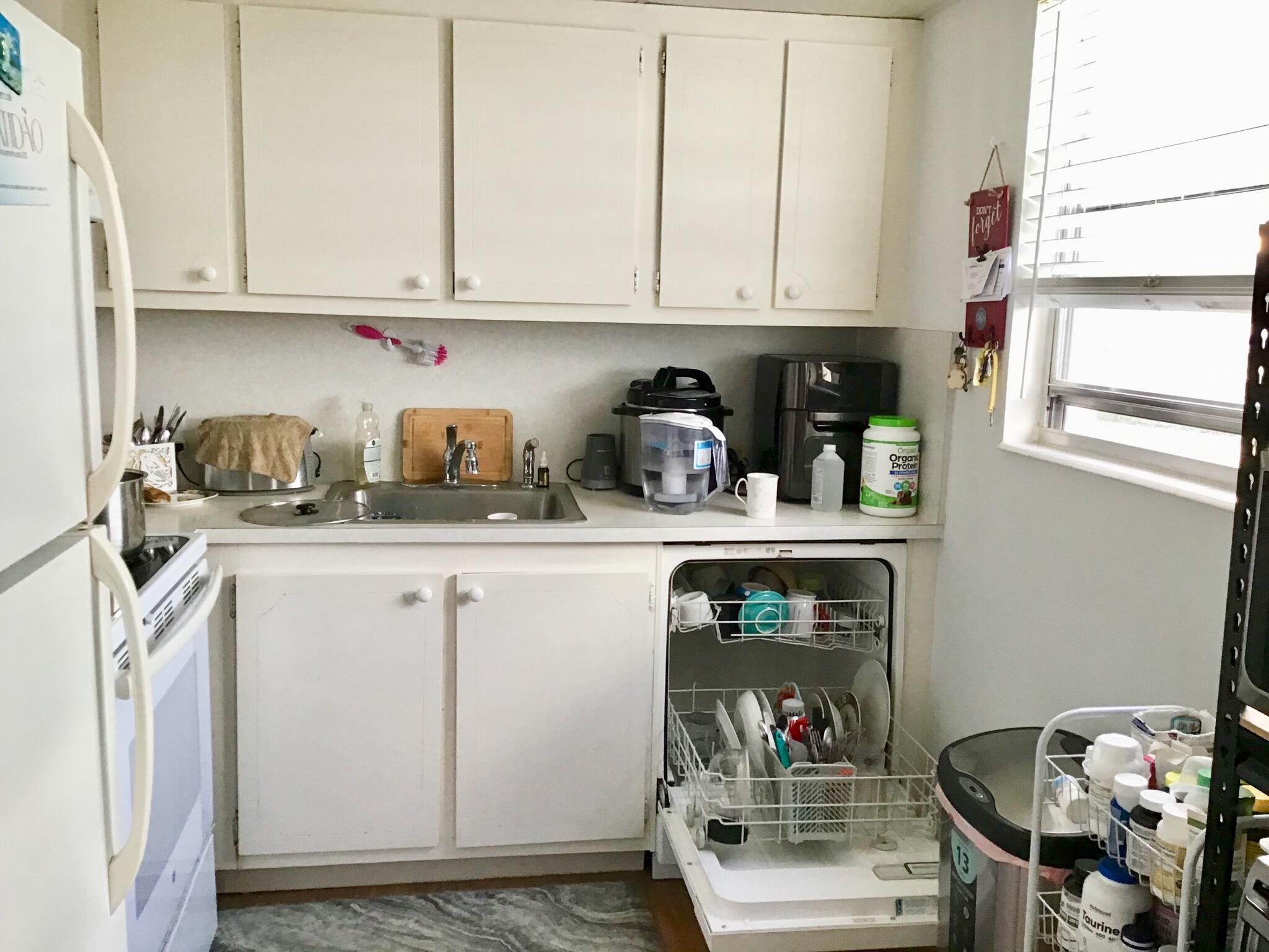 84 Brighton B Boca Raton, FL 33434 - Photo 3 of 35 a kitchen with white cabinets and a stove top oven