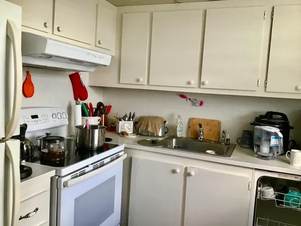 a kitchen with stainless steel appliances granite countertop a sink a stove and cabinets