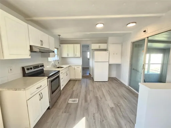 a kitchen with a cabinets and wooden floor