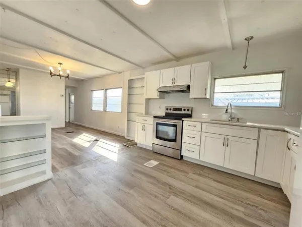 a kitchen with stove cabinets and wooden floor