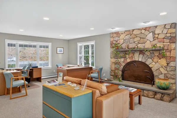 a living room with furniture a fireplace and a large window