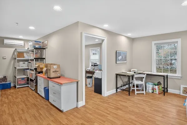 a view of a workspace with furniture and wooden floor