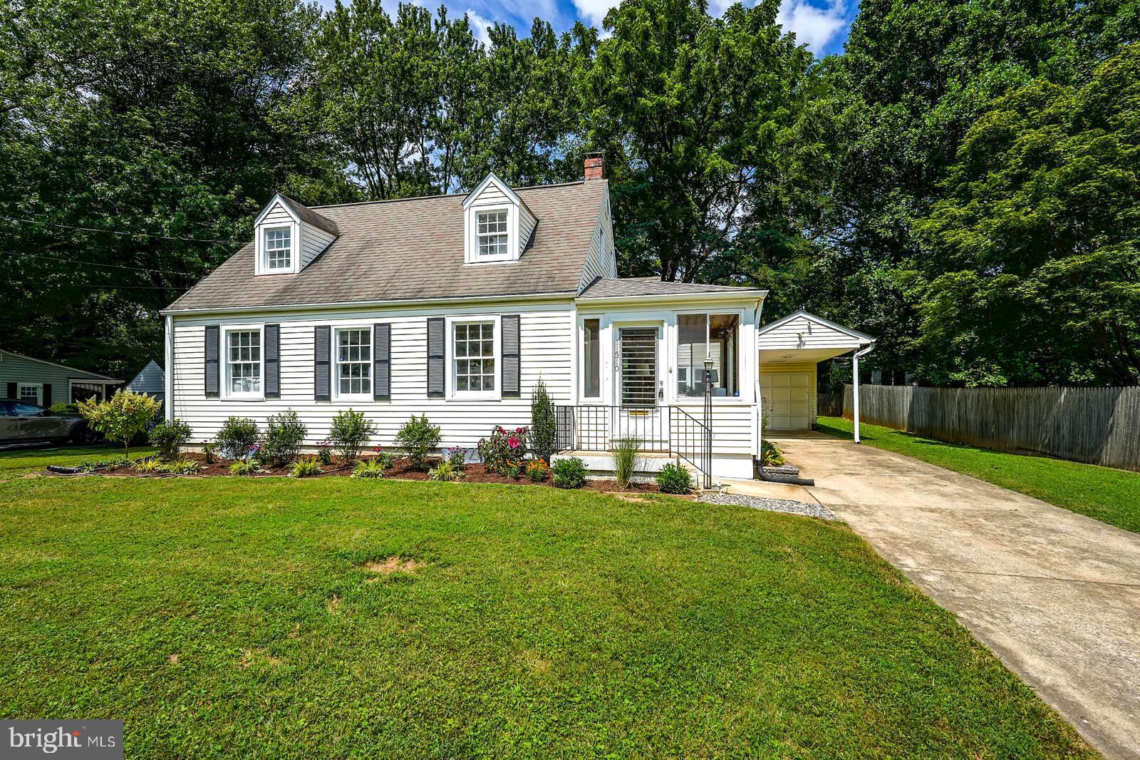 a front view of a house with a yard and trees