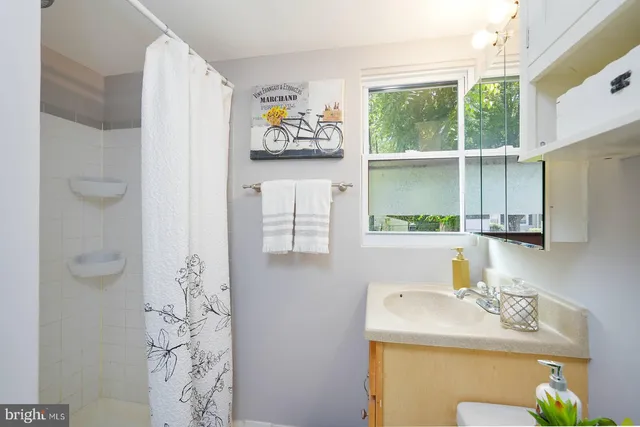 a bathroom with a sink mirror and window