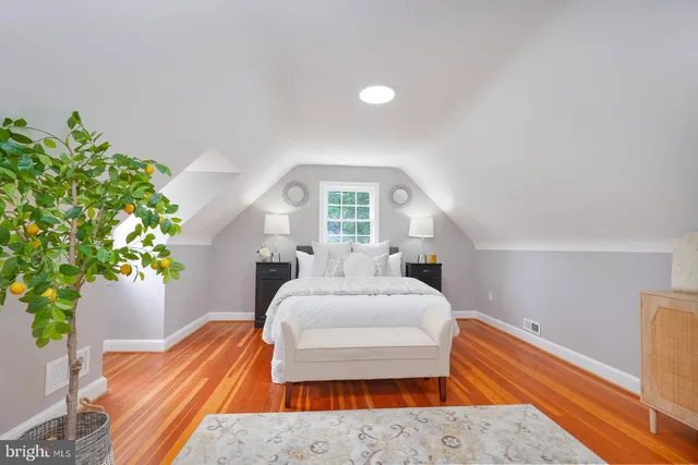 a bed sitting in a spacious bedroom next to a window