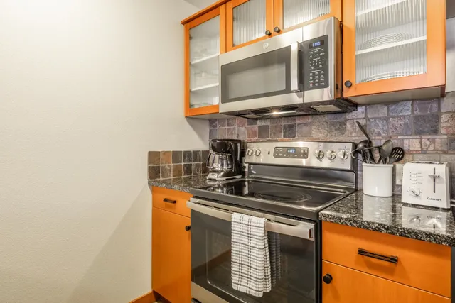 a kitchen with a stove a sink a dining table and chairs